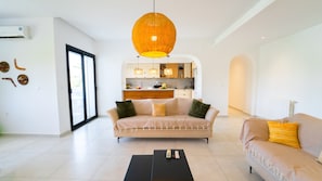 Ein modernes Wohnzimmer mit Sofa, Couchtisch und einer Pendelleuchte.
