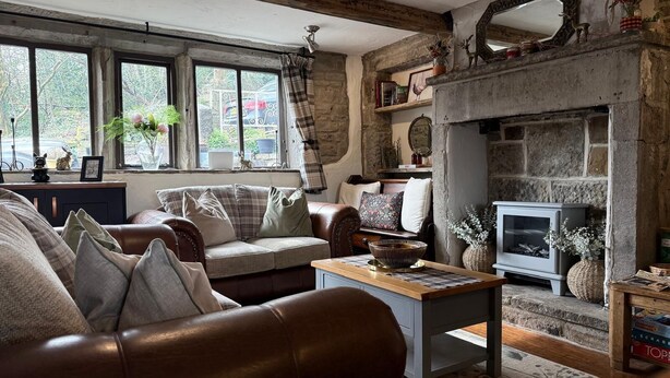 Ein gemütliches Wohnzimmer mit Kamin, einer Couch, einem Couchtisch und einem Fernseher.