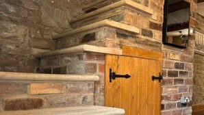 A stone staircase leading to a wooden door with a mirror above it. - Charming 17th Century 3 Bed Cottage in The Heart of the Pennines /Dog Friendly (Todmorden)
