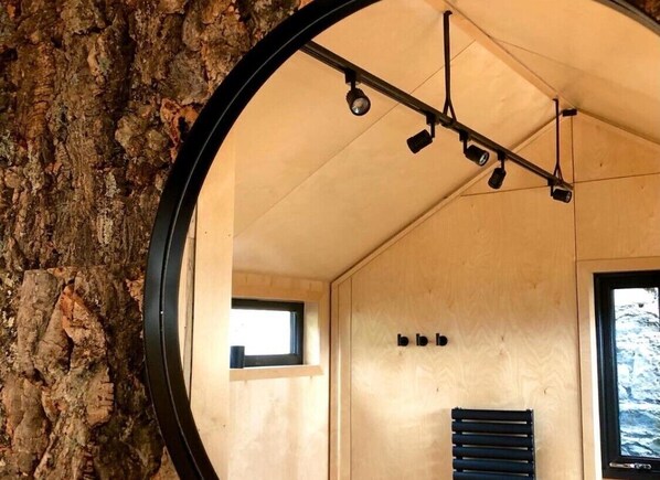 Una habitación con pared de madera, una ventana e iluminación empotrada en el techo.