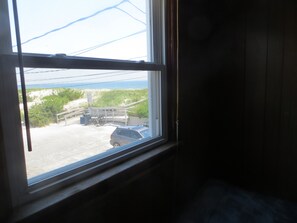 A window with a view of a parking area, a bicycle, and a car. - Adorable 3-bedroom house in charming Ship Bottom - 2nd from the beach. (Ship Bottom)