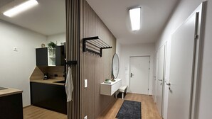 Une cuisine moderne avec un îlot central en bois, un banc intégré et un grand miroir.