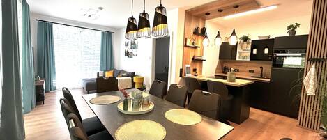 Un comedor moderno con una mesa larga, sillas e iluminación colgante.