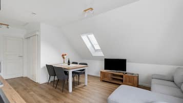 Eine moderne Loft-Wohnung mit Essbereich, Wohnzimmer und Fernseher.