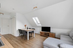 Un loft moderno con comedor, sala de estar y televisor.