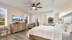 A bedroom with a bed, dresser, chair, desk, and a ceiling fan. - Historic Biltmore Village Retreat | 2 King En-Suites | Fireplace | Pets Welcome (Asheville)