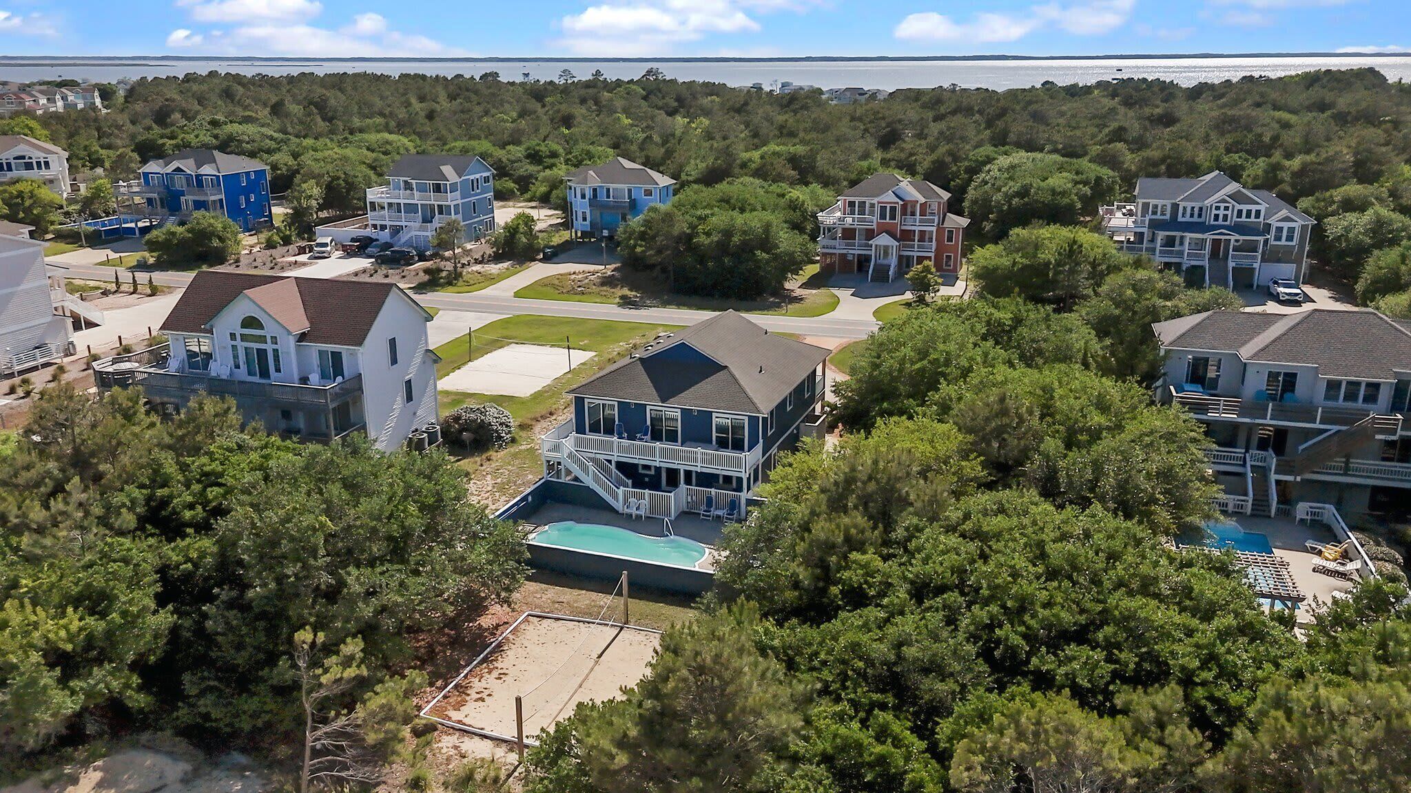 A residential area with houses, a swimming pool, and a view of the water.