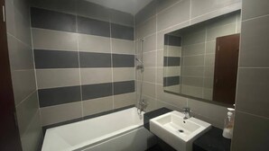 Ein Badezimmer mit Badewanne, Waschbecken und Spiegel.