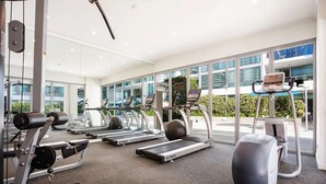 A gym with treadmills, elliptical machines, and weight equipment. - Riverfront Heated Pool, Gym, Sauna Steps to Casino (Broadbeach)