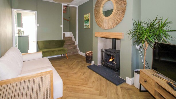 A living room with a sofa, a fireplace, a television, and a staircase leading to another room. - Cheshire Views (Malpas)