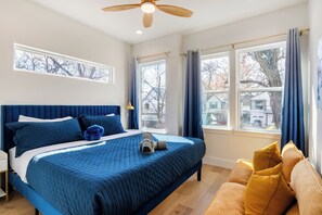 A bedroom with a large bed, a ceiling fan, and multiple windows. - Austin’s Special, Arcade Game, PoolTable & Sleep16+ (Austin)