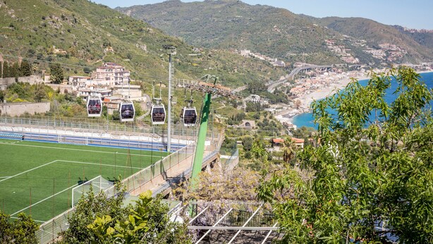 A sports field with a green track and goalpost, surrounded by hills and a coastal view. - 'Fabian's House' with Sea View in Taormina (Taormina)