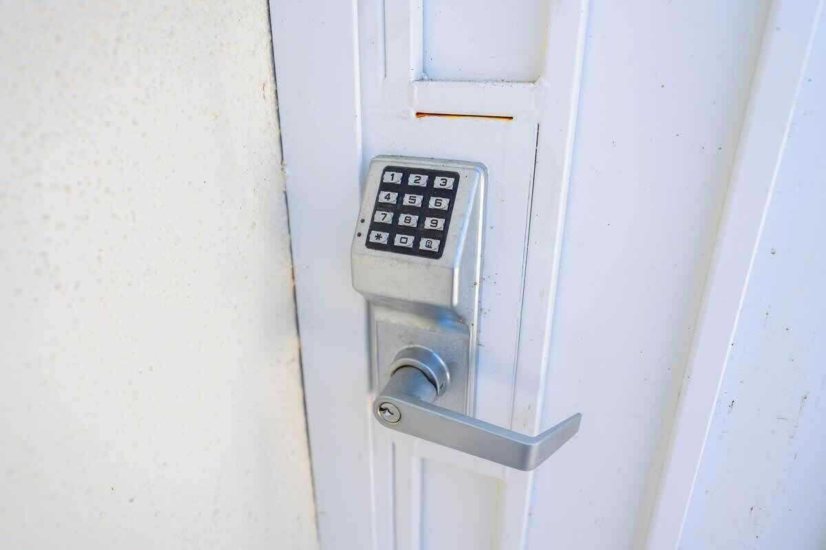 Una puerta con teclado numérico y manija palanca.