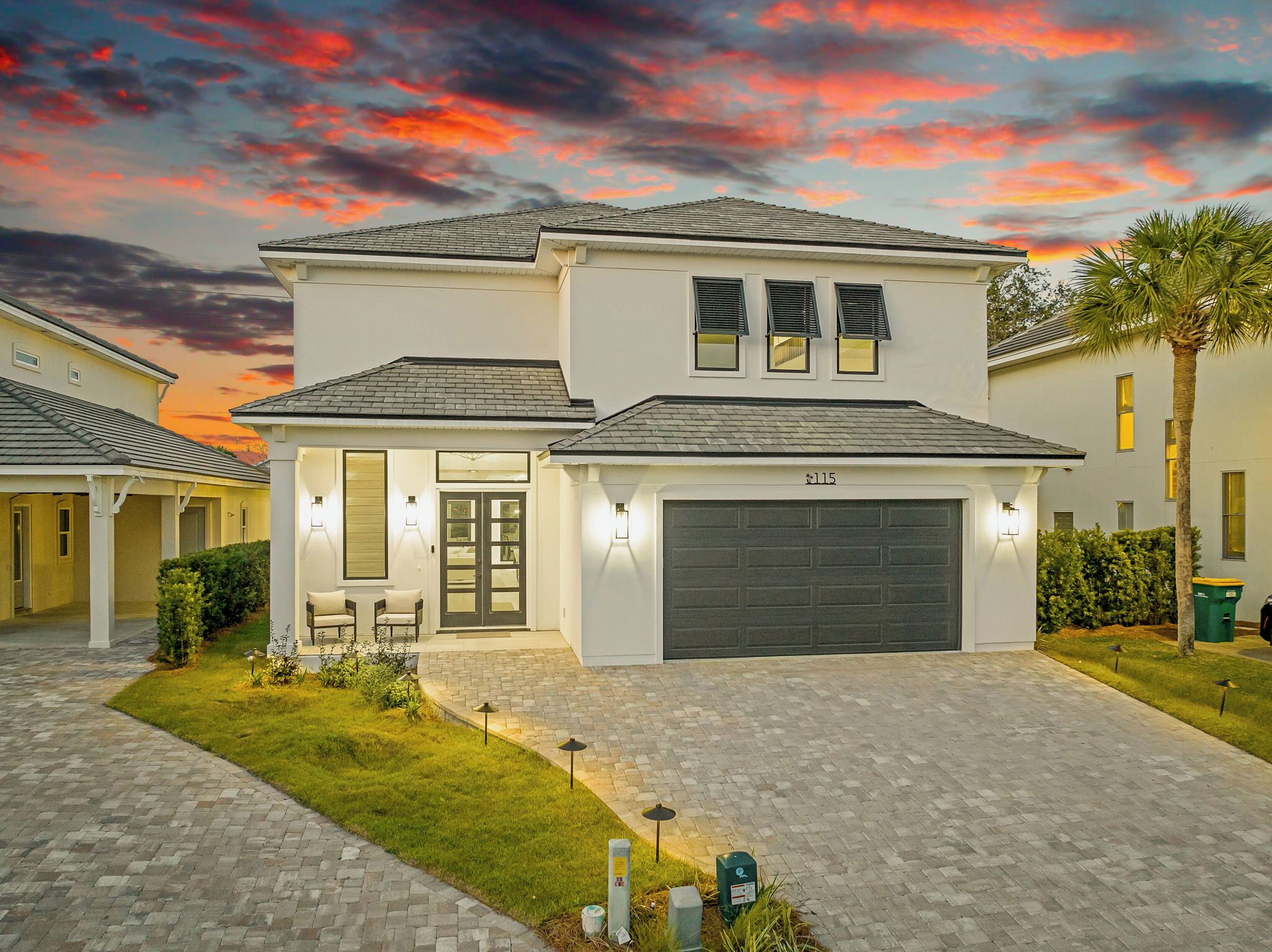 A two-story house with a garage, a covered patio, and a well-maintained lawn.