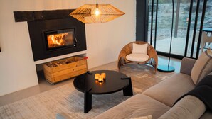 Una sala de estar moderna con chimenea, un sofá, un sillón y una mesita de centro.