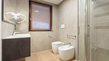 Vierpersoonskamer | Badkamer | Een douche, een haardroger, handdoeken, zeep