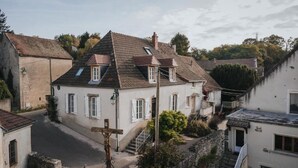 Ein traditionelles Gebäude im europäischen Stil mit einem steilen Satteldach, einer sichtbaren Treppe und einer schmalen Straße.