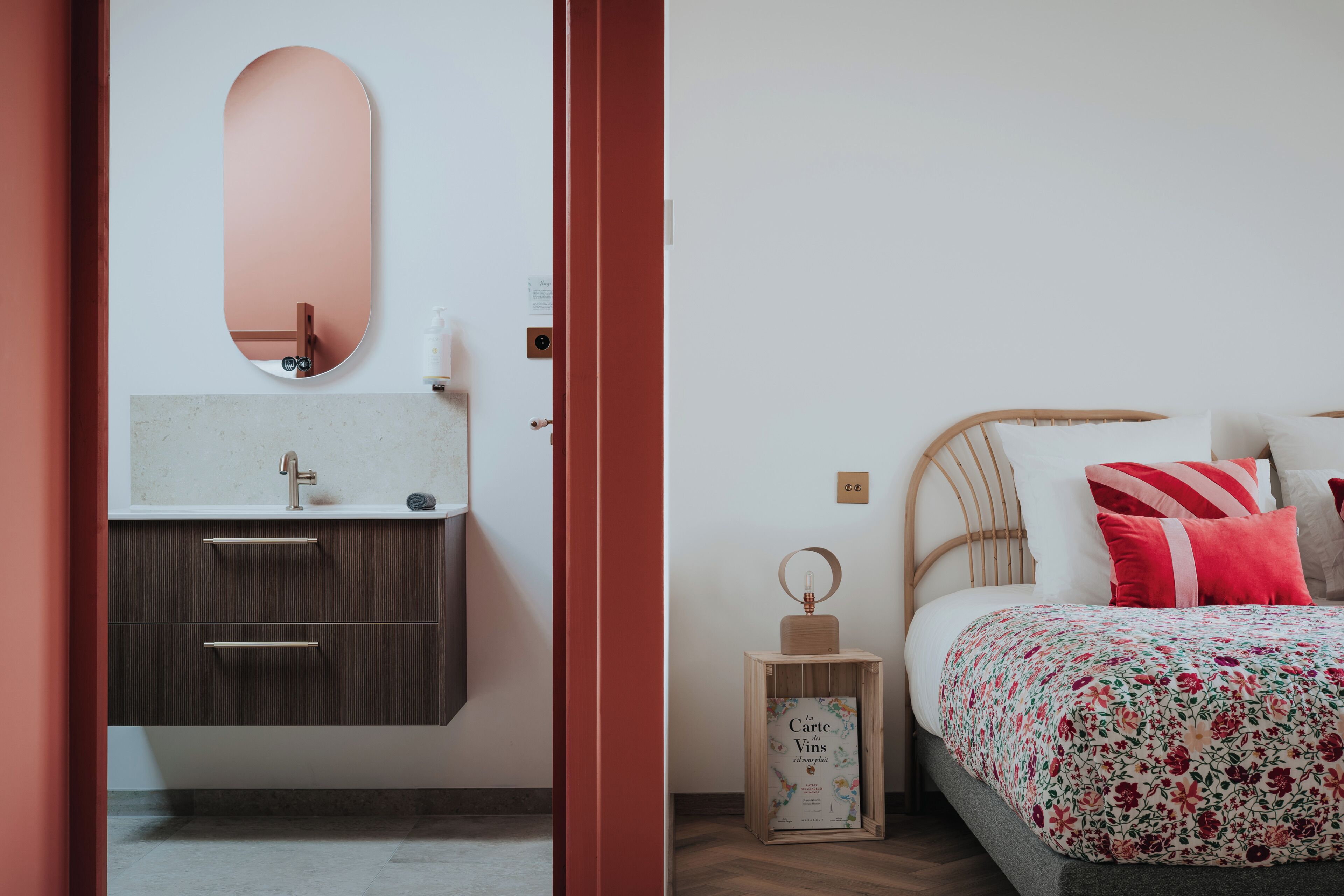 Une chambre à coucher avec un lit, des oreillers, une table de chevet et un miroir.