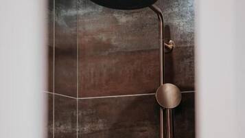 A shower with a modern design, including a curved showerhead and a control panel.