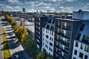 A modern multi-story building with a prominent geometric facade, large windows, and balconies.