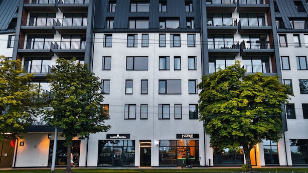 Un edificio moderno de varios pisos con balcones y amplias ventanas.