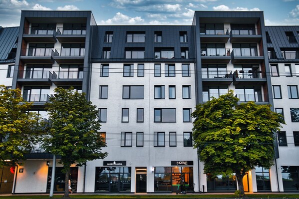 A modern multi-story building with balconies and large windows.