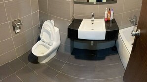 Ein modernes Badezimmer mit Toilette, Waschbecken und Badewanne.