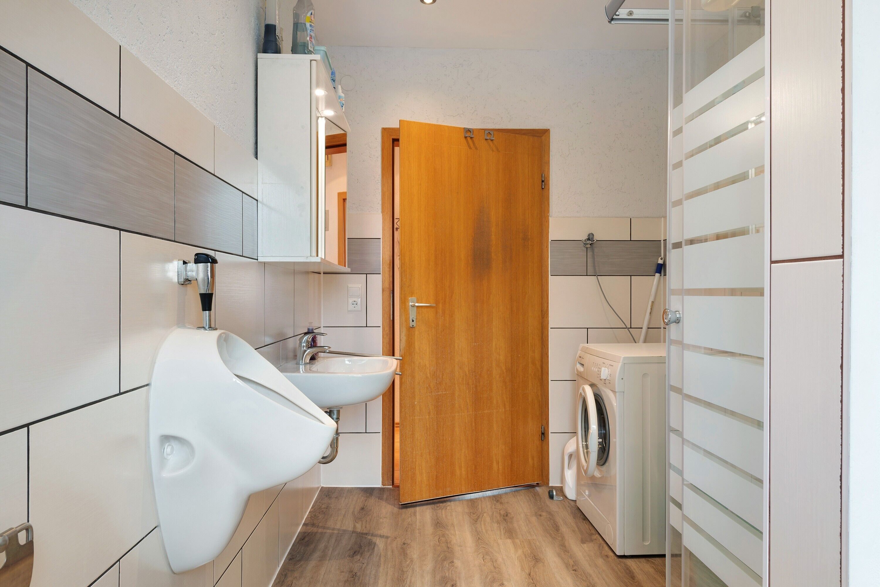 Un bagno moderno con un bidet, un lavandino e una lavatrice.