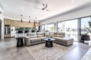 Een moderne woonkamer met een hoekbank, een salontafel en een eetgedeelte met stoelen.