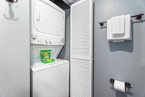A laundry room with a washing machine, a dryer, and a towel rack. - Kksr#4303 Direct Oceanfront, Top Floor, Ac! (Kailua-Kona)