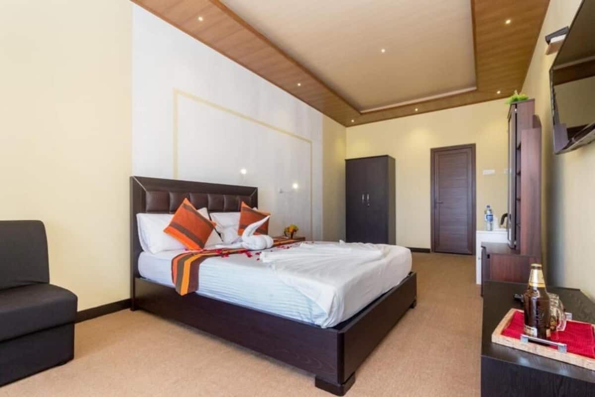 Ein Hotelzimmer mit einem Bett, einem Sofa, einem Schreibtisch und einem Kleiderschrank.