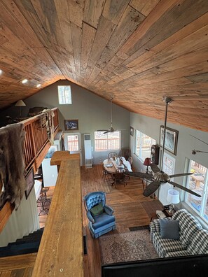 A loft-style living space with a wooden ceiling, a dining area, and a staircase. - Terrific 2-bedroom country house in charming Woodland Park (Woodland Park)