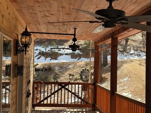 A wooden porch with a ceiling fan, a railing, and a view of a snowy landscape. - Terrific 2-bedroom country house in charming Woodland Park (Woodland Park)