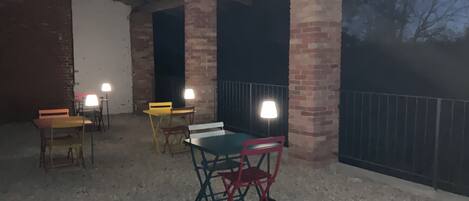 An outdoor patio area with brick pillars, a table, and chairs.