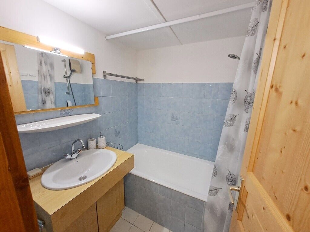 Une salle de bain avec un lavabo, un miroir et une douche.