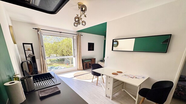A modern room with a desk, chairs, a mirror, and a window with curtains. - Beautiful 54 m² apartment with parking in Nantes (Nantes)