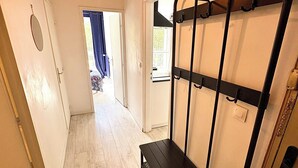 A hallway with a bench, a coat rack, and a door leading to a room. - Beautiful 54 m² apartment with parking in Nantes (Nantes)