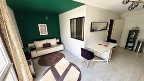 A modern living room with a sofa, a desk, and a dining area. - Beautiful 54 m² apartment with parking in Nantes (Nantes)