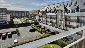 Un edificio residencial con varios balcones y una zona de estacionamiento.