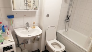 A bathroom with a white sink, toilet, and bathtub. - Room-cozy Guest Room in Green Uppsala - (Uppsala)