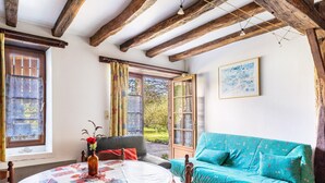 Una habitación con una mesa redonda, un sofá y una ventana con cortinas.