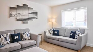 Een woonkamer met twee banken, een lamp en een groot raam.