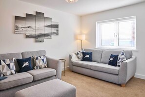 A living room with two sofas, a lamp, and a large window. - Host & Stay | Abbey View House (Whitby)