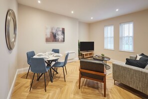 A modern living room with a dining area, a flat-screen TV, and a sofa. - Host & Stay | Flat 2 @ Temperance House (Saltburn-By-The-Sea)