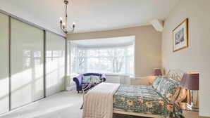 Une chambre à coucher avec un lit, une fenêtre, une chaise et un lustre.