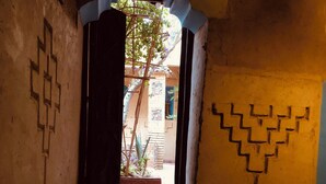 A narrow stairway with a decorative wall pattern, leading to an open doorway. - Kasbah berbère Ouriz (Tansifte)