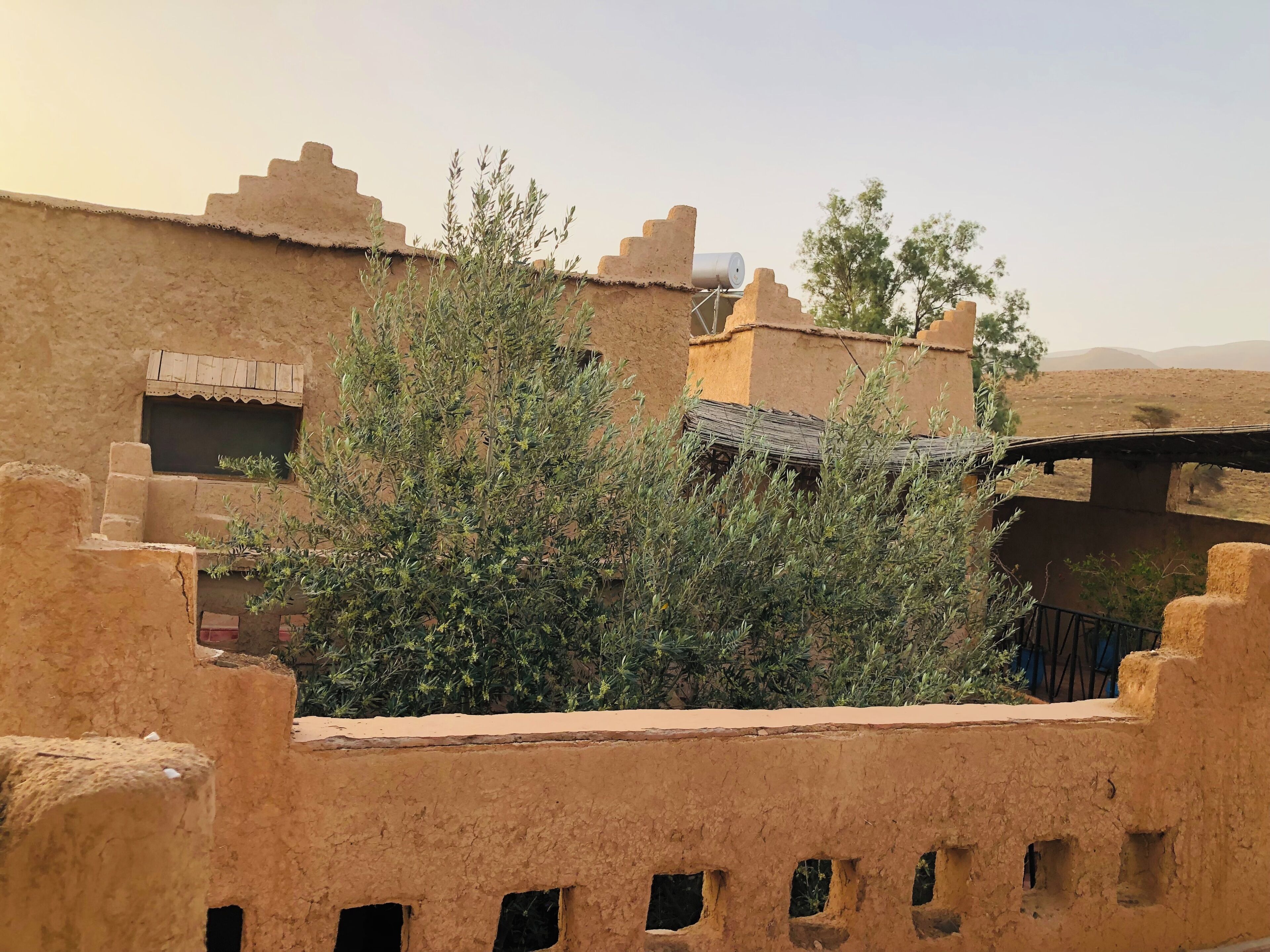 A traditional building with a flat roof, a window with a decorative frame, and a small balcony.
