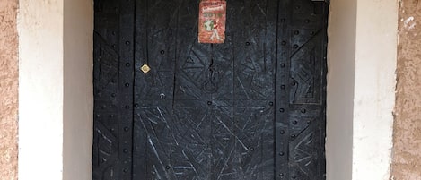 Uma porta preta com uma placa em cima que diz 'Thambres Dhules'.