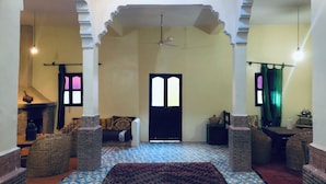 A room with a patterned floor, a central doorway, and a ceiling fan. - Kasbah berbère Ouriz (Tansifte)