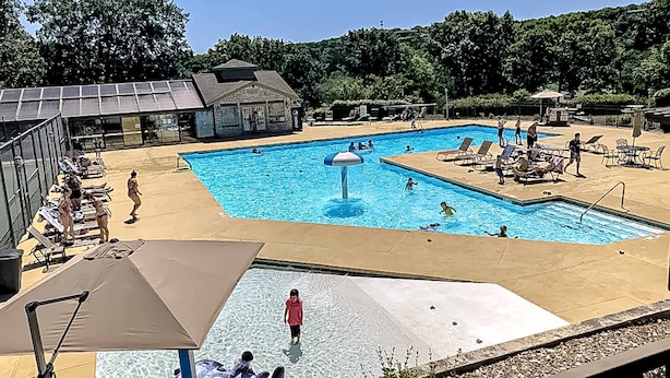 Piscina com várias pistas de natação, espreguiçadeiras e um toboágua.